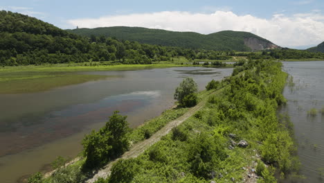 Damm-Mit-Unbefestigter-Straße,-Die-Den-Stausee-Des-Tkibuli-sees-In-Georgia-Teilt