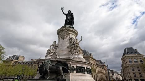 people walking by a large statue