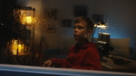 child sitting by window at night