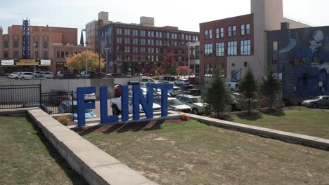 flint, michigan blue city sign with drone video moving low at an angle