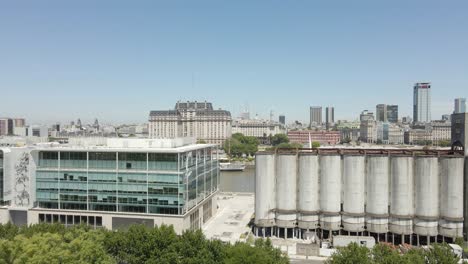 office building next to queen of holland square in puerto madero, buenos aires, argentina with distant view of libertador building - aerial drone