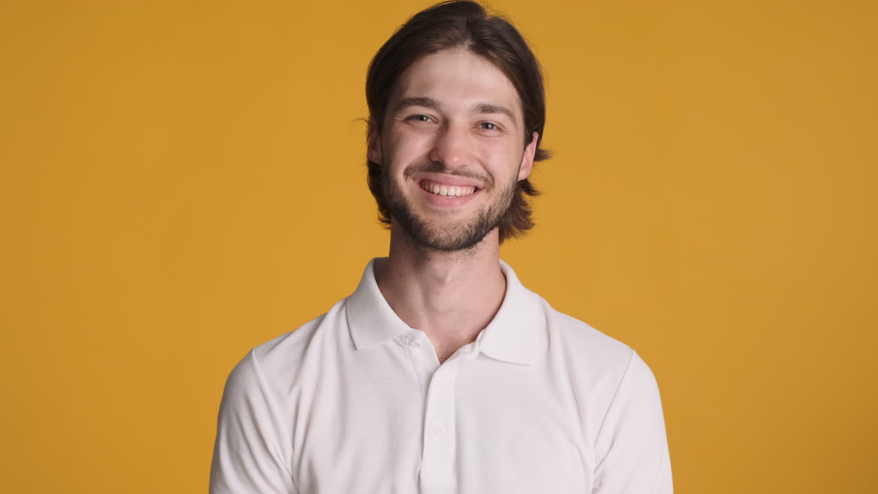 Caucasian man in front of camera on yellow background.