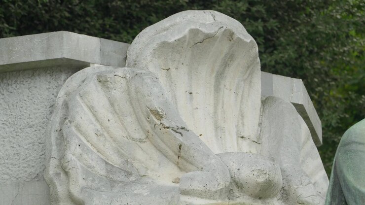 Primo piano di una scultura di ala d'angelo in pietra bianca consumata dalle intemperie a Oviedo, Spagna