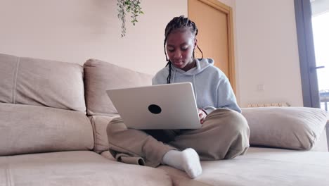 mujer usando una computadora portátil en el sofá