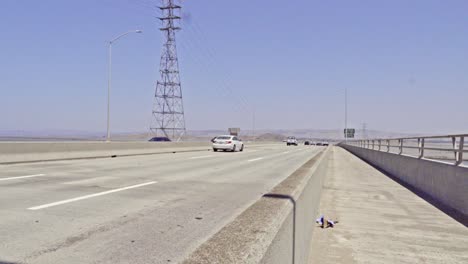 traffic on top of dumbarton bridge close up from the side of the highway cars zooming past