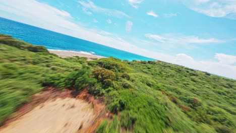 Dynamic-fpv-flight-over-green-landscape-and-hidden-sandy-beach-beside-blue-Caribbean-Sea-in-Dominican-Republic