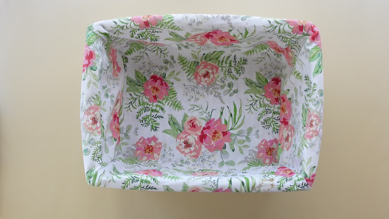 Person Holding a Fabric Basket with Floral Pattern