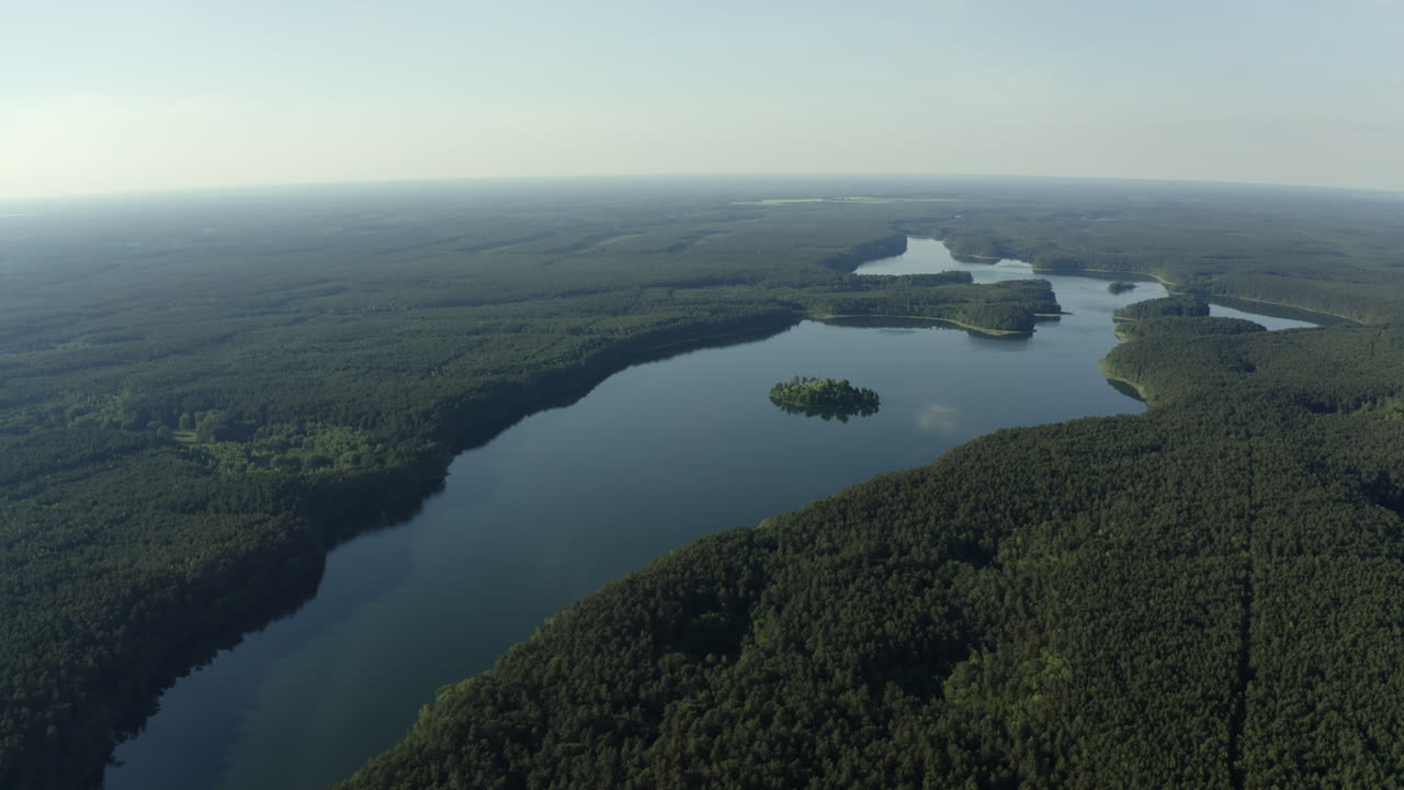 Scenic aerial establshing of a meandering river cutting through Drawieński National Park, surrounded by lush greenery with small islands