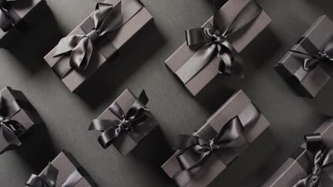 overhead view of black gift boxes tied with black ribbons on black background