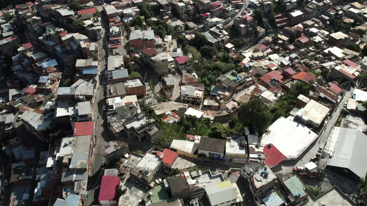 Aerial tilt-up over Nazareno buildings, Petare, Miranda, Venezuela, with green hills