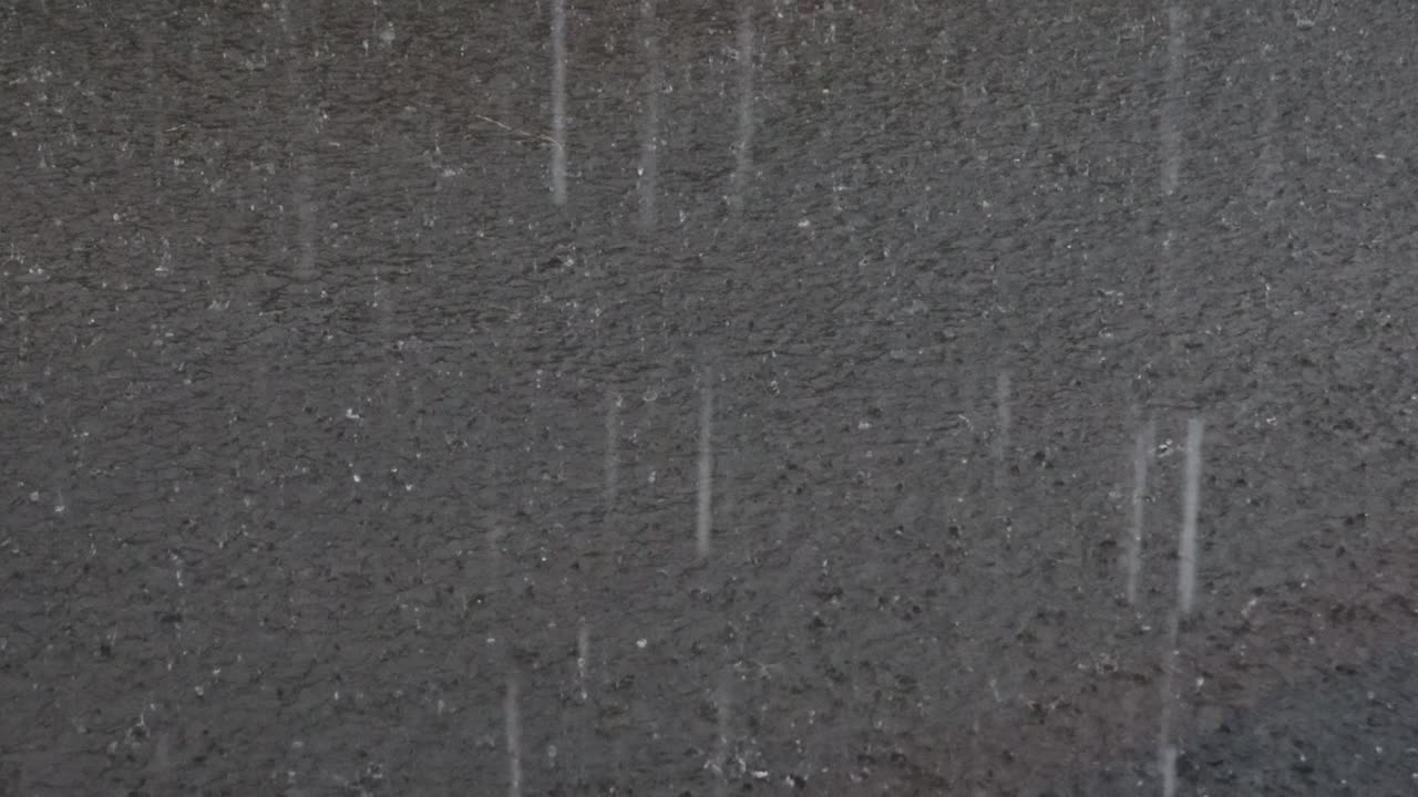 Kraftig regn, regndråber på flodens overflade med et uregelmæssigt mønster.