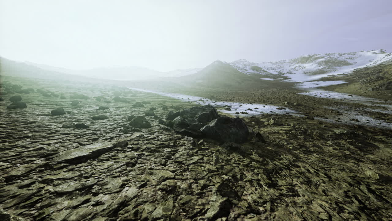 Vast desolate landscape revealing rocky terrain under a pale sky