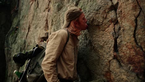 Hiker-Coming-Close-To-Rocky-Wall-Licking-To-Identify-Minerals-,-Dürnstein