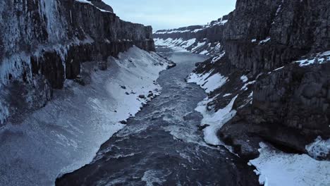 river flowing between frozen cliffs