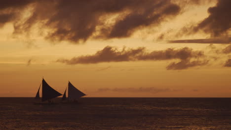 slow motion panning shot of boracay beach and sail boats in silhouette