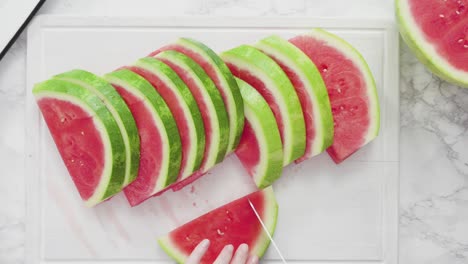 slicing red watermelon into small pieces