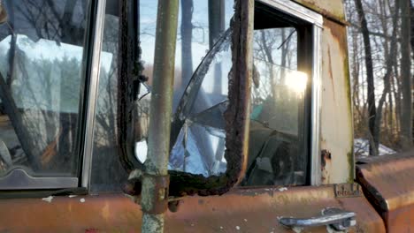 rusted old truck driver side door with broken wing mirror, sunlight reflecting in glass