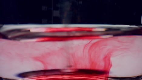 tubo de ensayo con agua y reactivo rojo. vidrio de laboratorio de primer plano con sangre