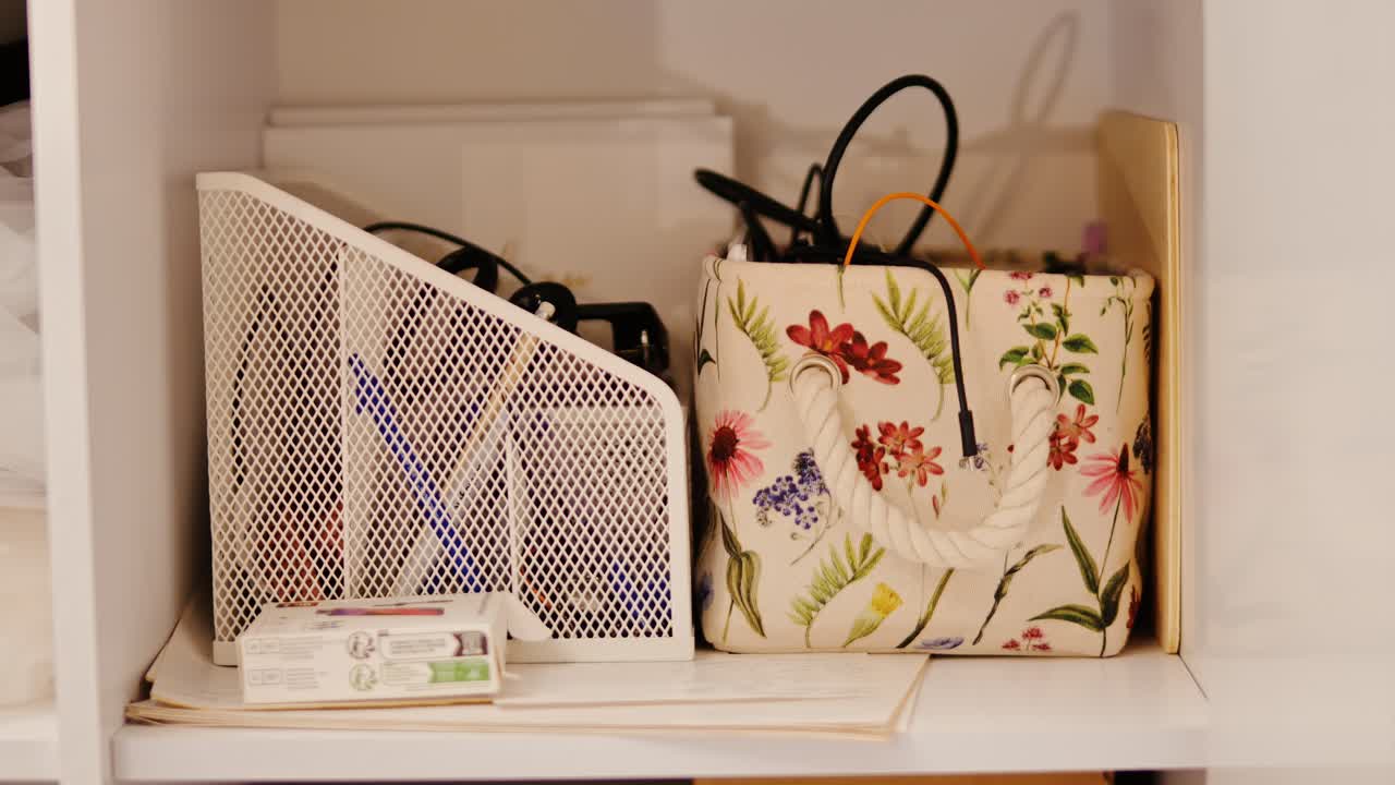 Ordentliches Lagerregal, Stofftasche mit Blumenmuster und weiße Halterung, die einen ordentlichen Lebensstil zeigen