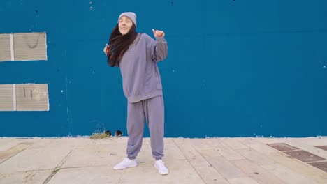 woman dancing in front of a blue wall
