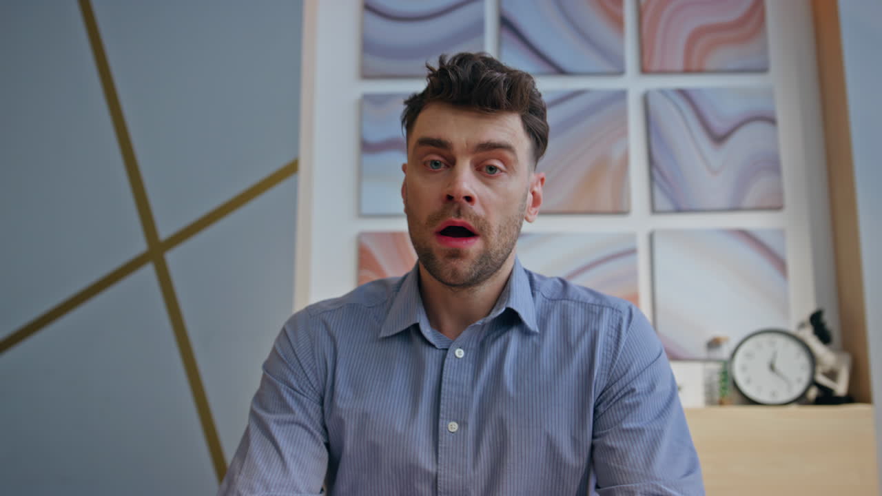 Designer furioso che discute in videochiamata in una stanza moderna, ritratto. Uomo nervoso che parla.