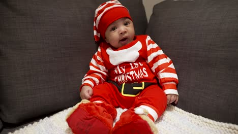 Adorable-Lindo-Bebé-De-Dos-Meses-Con-Traje-Festivo-Rojo-De-Navidad-Sentado-En-El-Sofá-Y-Bostezando