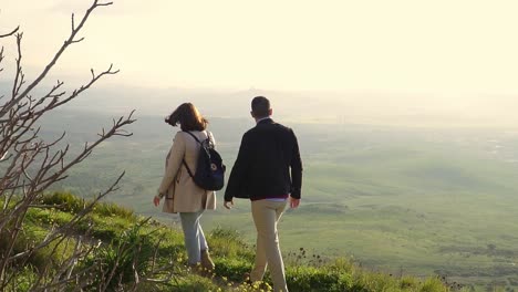 Slow-Motion-Shot-Of-Man-And-Woman-Walking-Near-Cliff-Edge-Enjoying-Rural-View