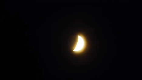 Time-lapsed-tracking-shot-of-moon-moving-from-behind-trees-and-through-the-sky-with-dramatic-streaking-clouds