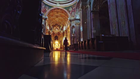 un hombre caminando sobre la alfombra roja hacia el altar dentro de la basílica religiosa de la visita menor de la virgen maría en svatý kopeček en la república checa.