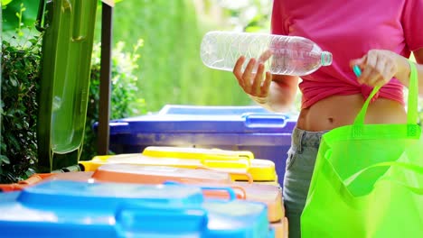 woman recycling a plastic bottle