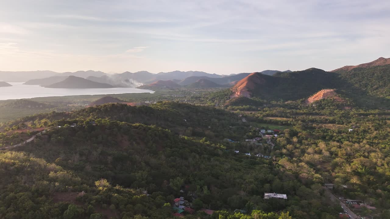 Drone view of Coron Town, Philippines during sunset with scattered islands, calm sea, forested hills, and boats gliding through the golden waters
