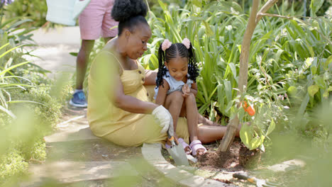 Feliz-Nieta-Afroamericana-Con-Abuela-Trabajando-En-El-Jardín,-En-Cámara-Lenta