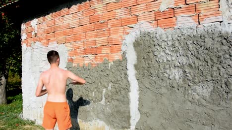 young man working hard to build facade of a house this summer