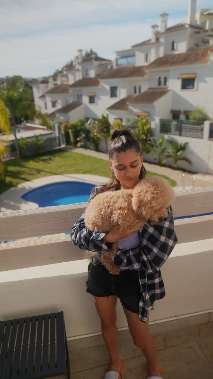 mujer joven con perro en el balcón