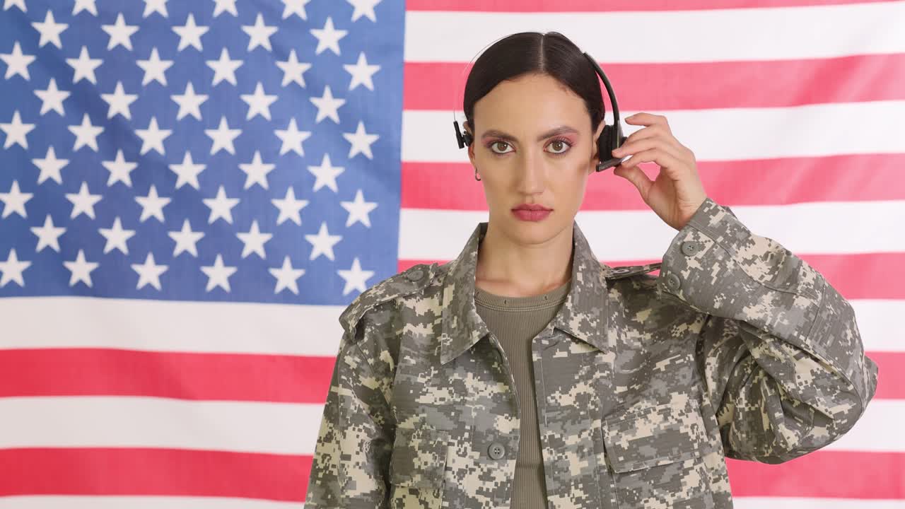 Soldatessa che indossa l'auricolare davanti alla bandiera americana