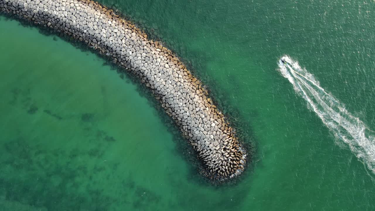 두바이 맘자르 해변의 드론 공중 전망, 제트 스키를 탄 남자, 낙원의 수상 스포츠, 아라비아 해의 해안 청록색 맑은 물, 최고의 관광 명소, 4k 영상