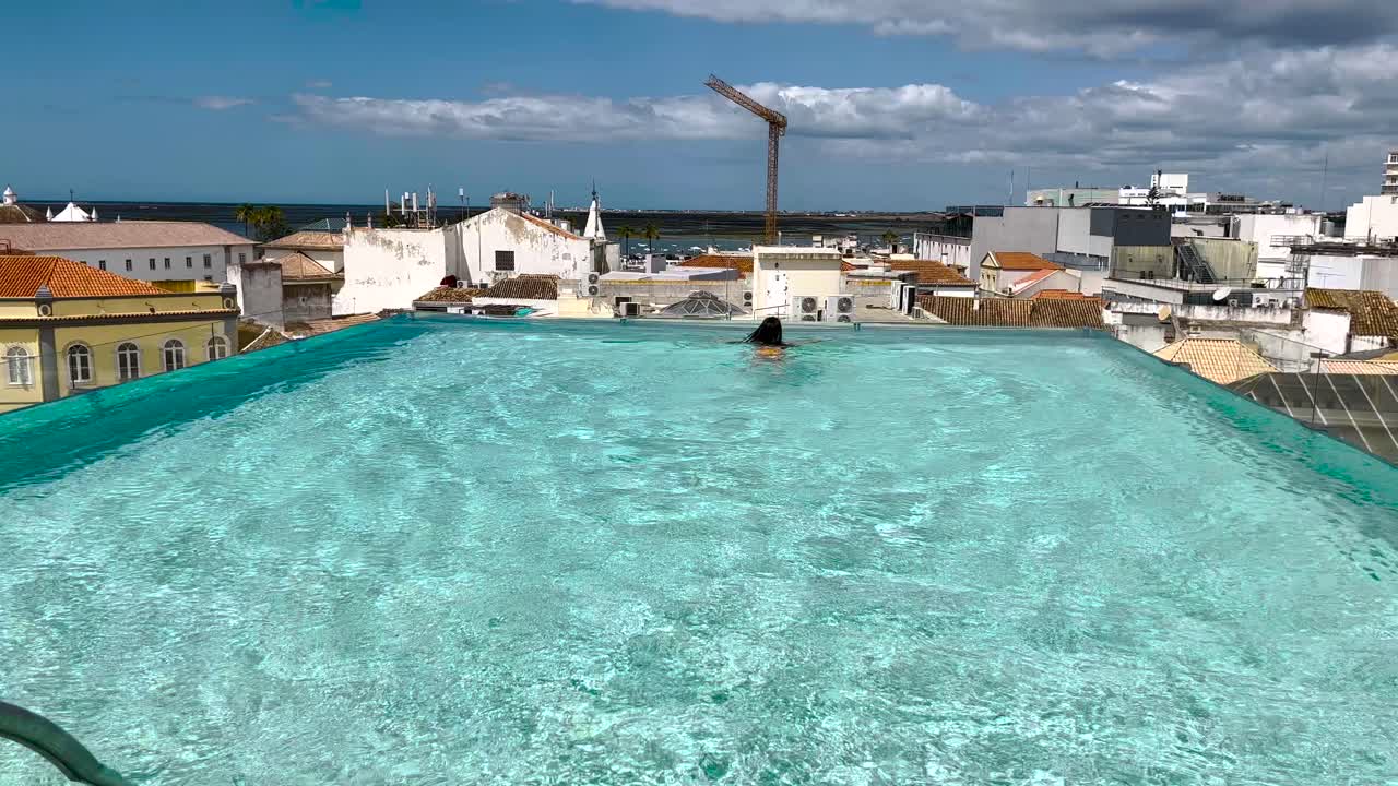 알가르베 의 파로 의 중심 에 자리 잡은 야외 수영장 에서 수영 하는 여자