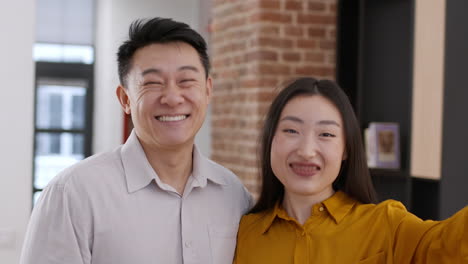Happy Couple Taking a Selfie in an Office