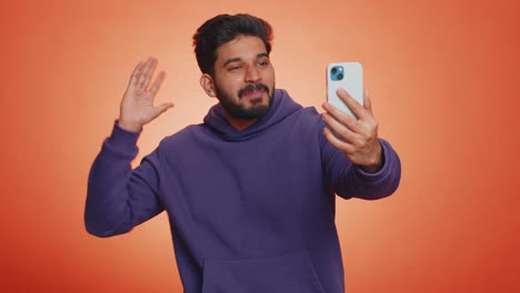 Indian-young-man-traveler-blogger-taking-selfie-on-smartphone-communicating-video-call-online-stream