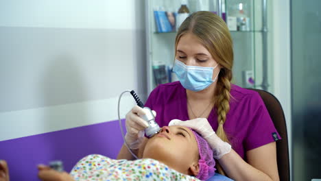 beautiful woman with a beautician on the procedures. spa procedures. anti aging face skin treatment.