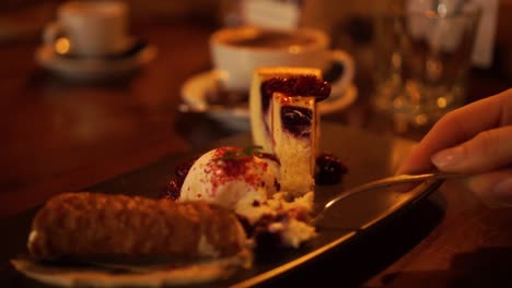 Cámara-Lenta---Mujer-Comiendo-Postre-De-Pastel-De-Queso-Dulce-Con-Helado-Con-Cuchara-En-Un-Acogedor-Restaurante-De-Lujo---Cerrar