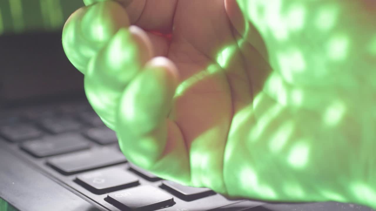 Computer code reflecting on hands and fingers close up shot