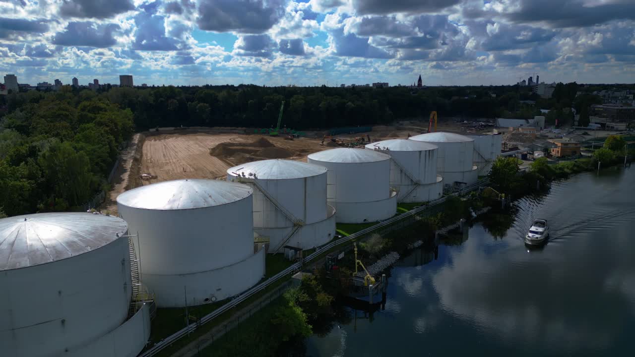 Decommissioning of Storage depot for petroleum products storage silos and containers. Industrial storage tanks holding oil and gas products. Dramatic aerial view flight ascending drone