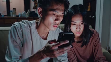 couple looking at smartphone at night