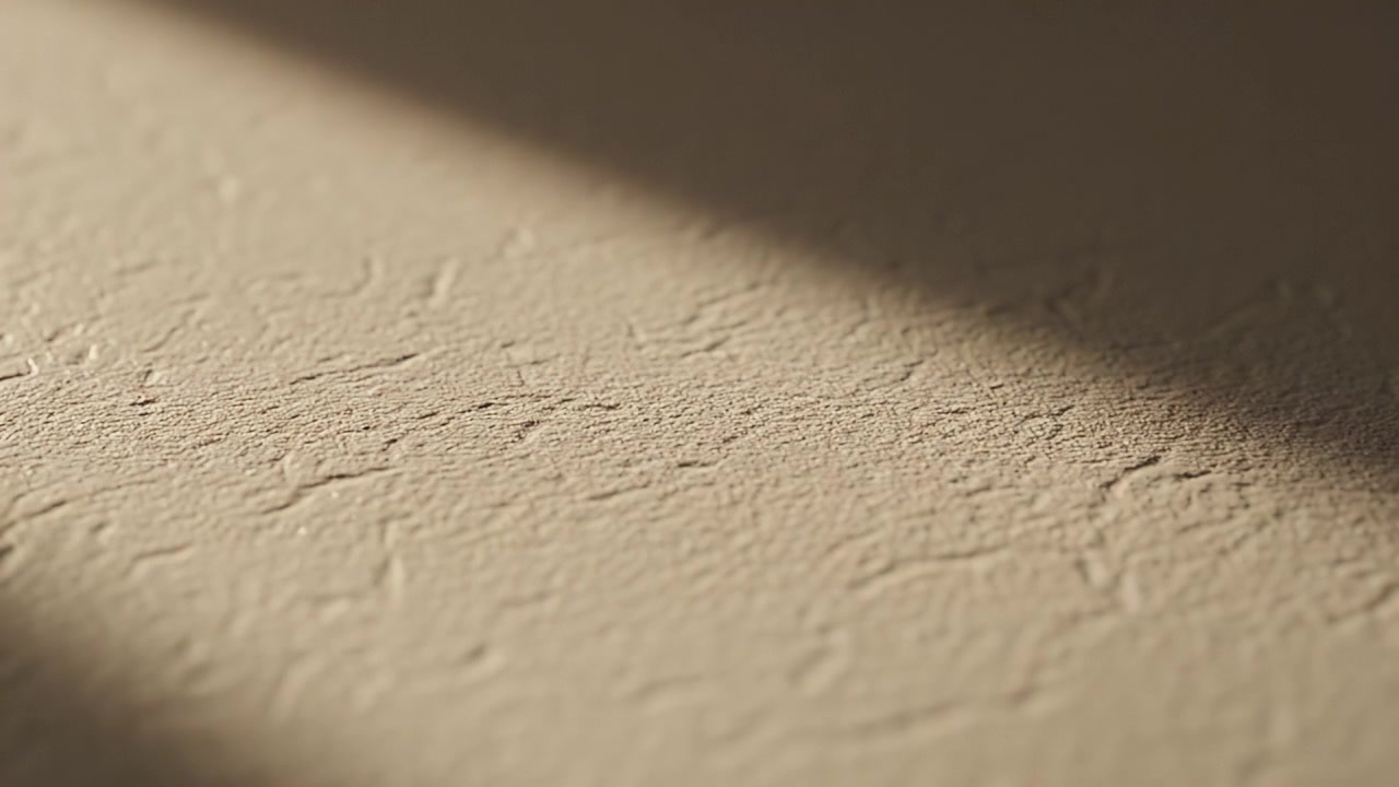 Sunlight Moving Across Textured Beige Surface