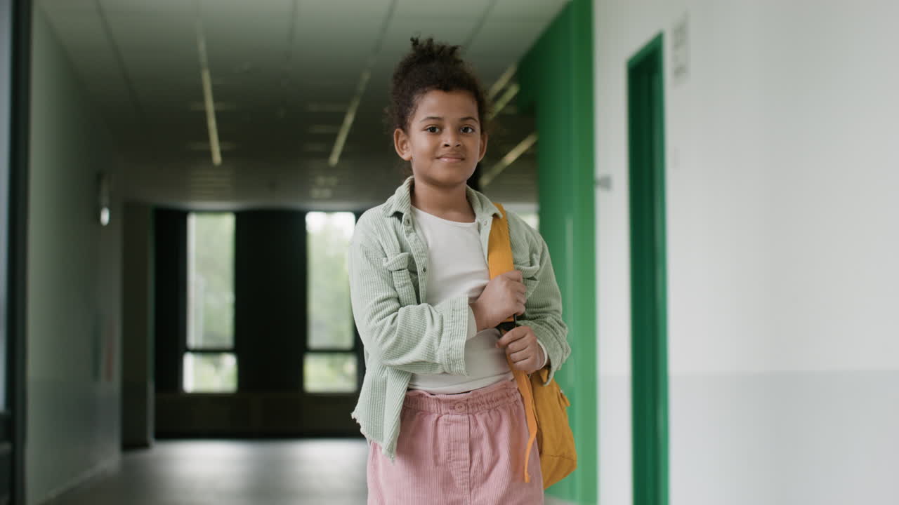 Schoolgirl looking at camera in school corridor.