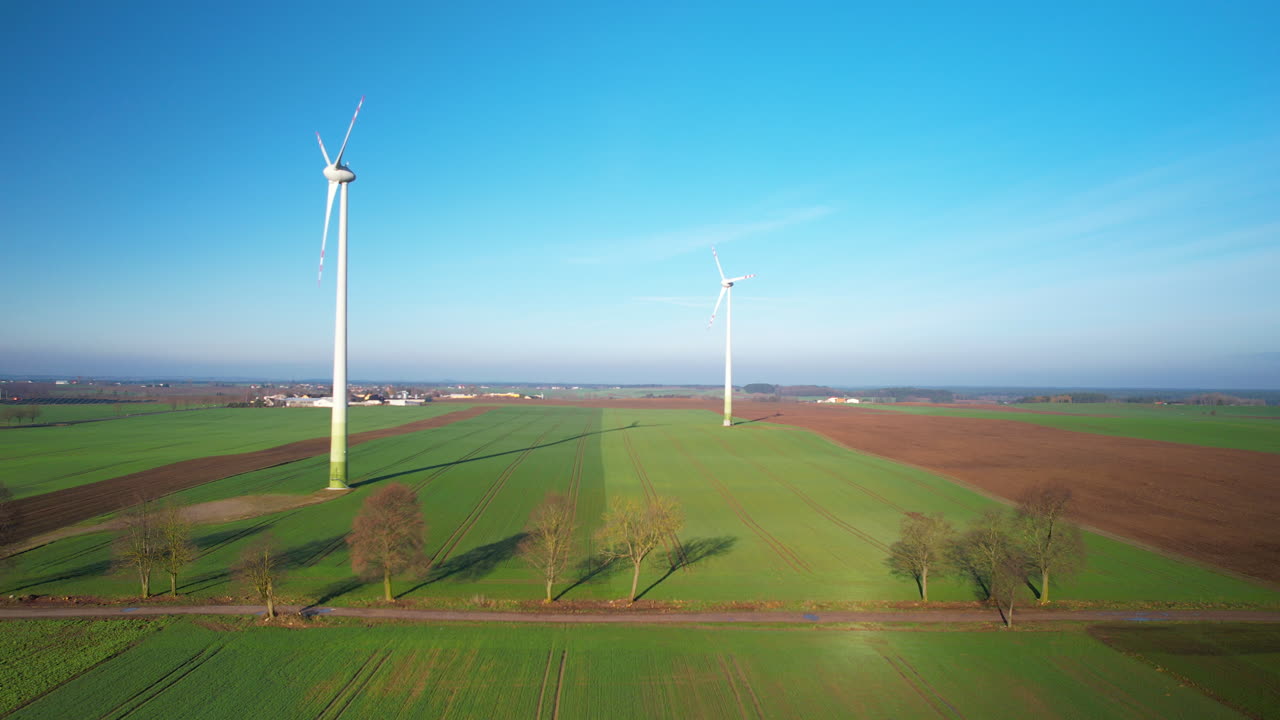 초록색 필드에서 회전하는 프로펠러를 가진 두 개의 풍력 터빈의 공중 뷰