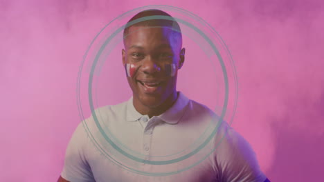 man with face paint and circular animation design on pink background