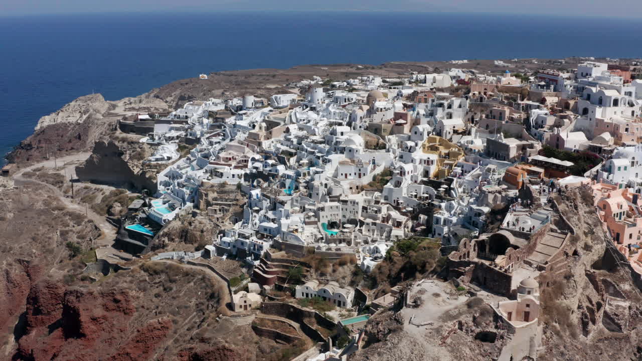 vista panorámica de la ciudad costera de oia en el extremo noroeste de santorini en grecia - toma aérea de drones