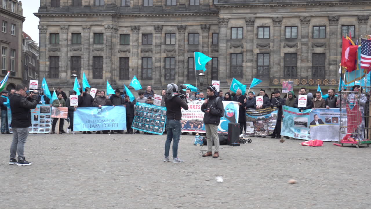 Panning shot of a East Turkestan demonstration against the Chinese cultural genocide of Uyghurs, in the middle of Dam Square in Amsterdam.